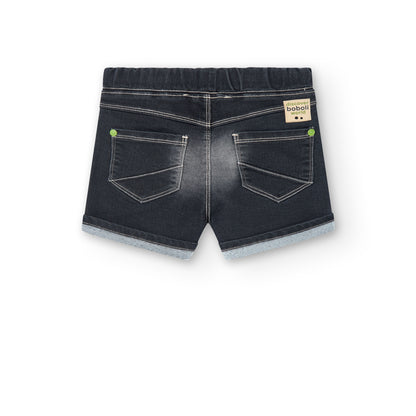 Bermudas jeans de niño Boboli color gris oscuro con detalles desgastados, y remaches en color verde, goma y cordones en la cinturilla, bolsillos delante y detras