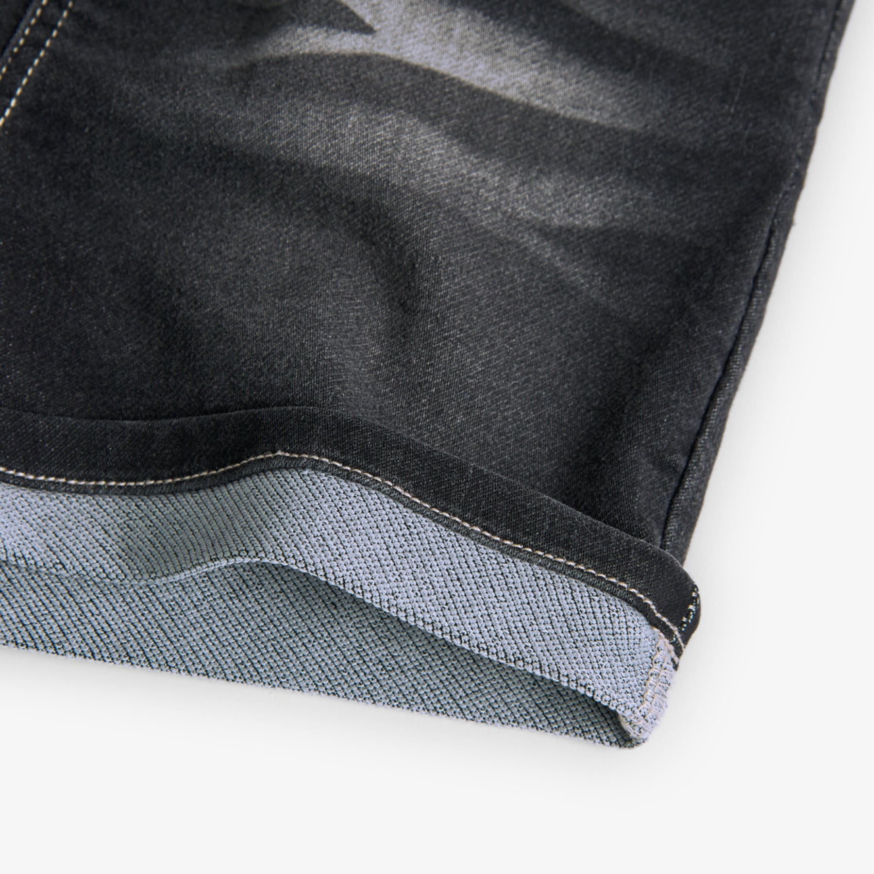 Bermudas jeans de niño Boboli color gris oscuro con detalles desgastados, y remaches en color verde, goma y cordones en la cinturilla, bolsillos delante y detras