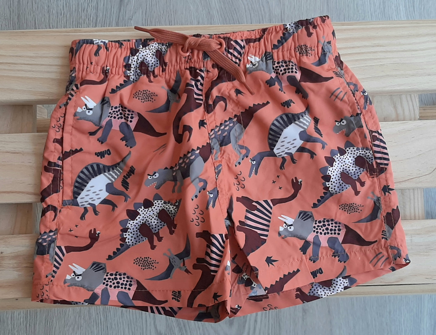 bañador de niño tipo bermudas con cordones color naranja con dinos Losan