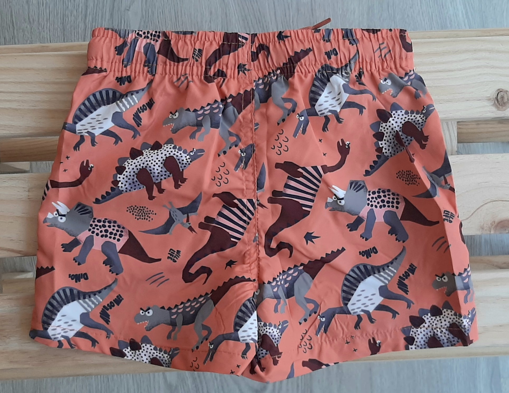 bañador de niño tipo bermudas con cordones color naranja con dinos Losan