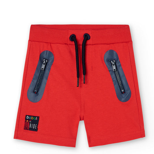 Bermudas de niño en color rojo con bolsillos delanteros con cremallera y bolsillo en la parte de atrás ajustable en la cintura con goma y cordones Boboli